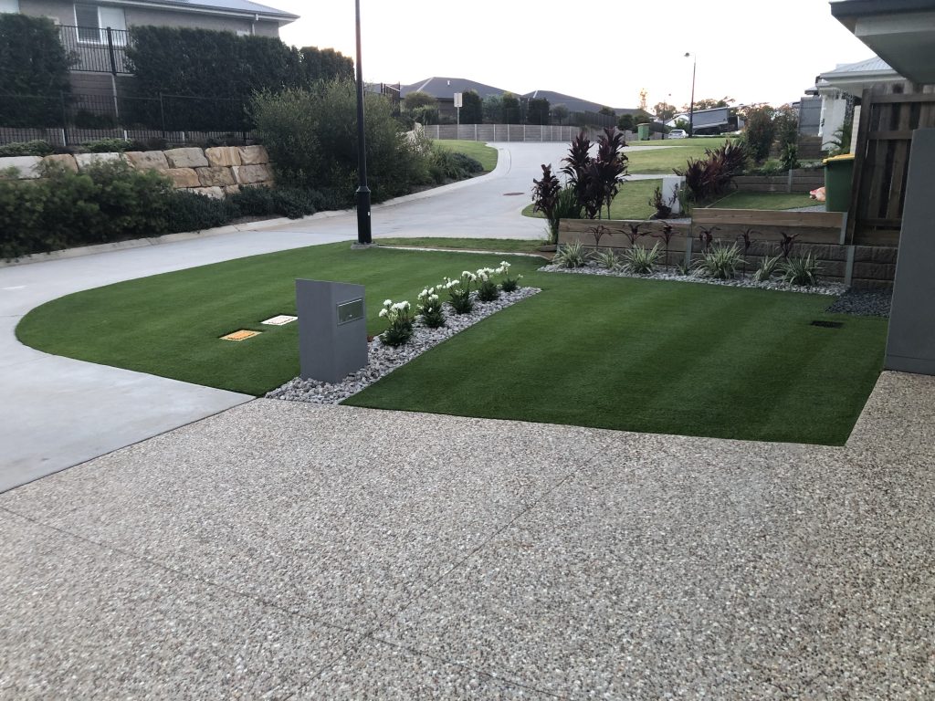 Dark green lawn cut with two horizontal stripes next to stone driveway | featured image for Jason - Thornlands.