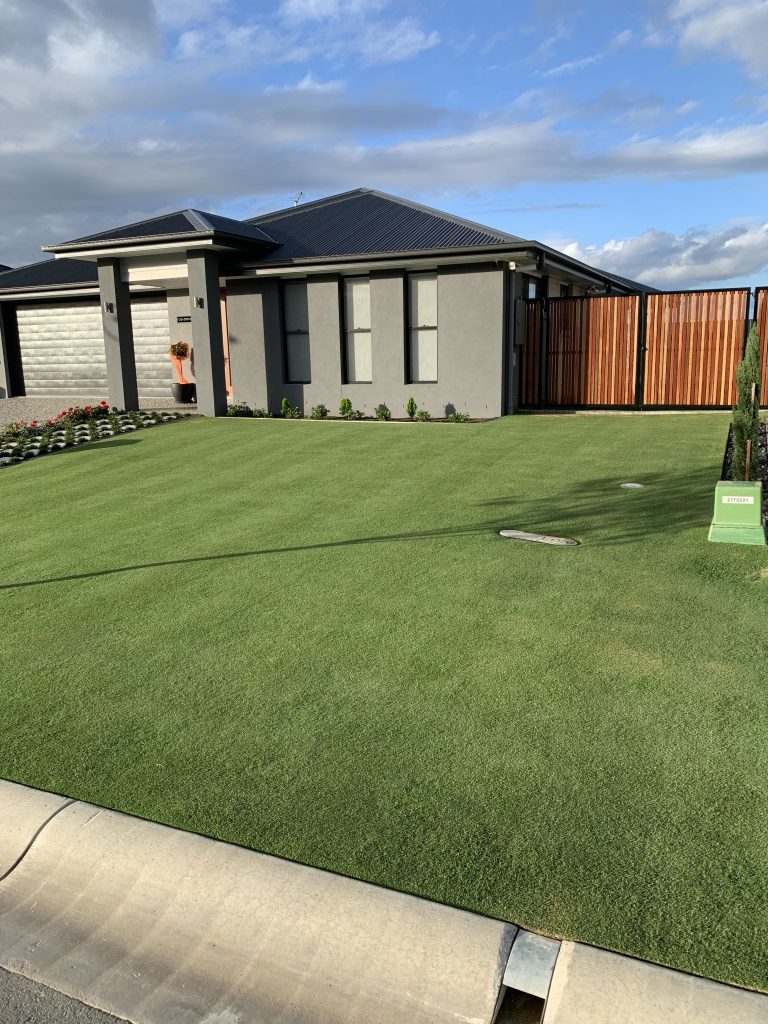 Moss green front lawn with a grey home in the background | featured image for Byron - Petrie.