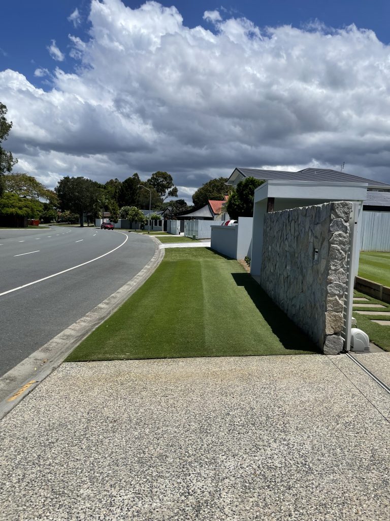 Rectangle shaped patch of health lawn in front of stone wall | featured image for Mick - Mermaid Waters.