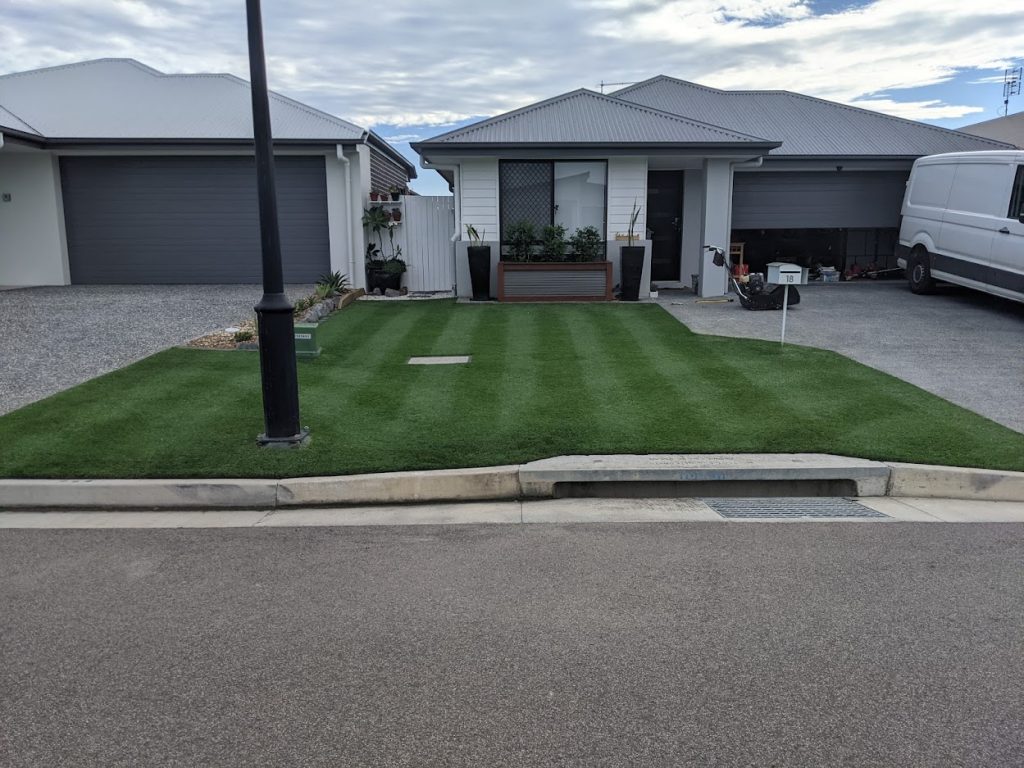Dark green lawn cut to display two shades of green in front of a white house | featured image for Daniel - Deception Bay.